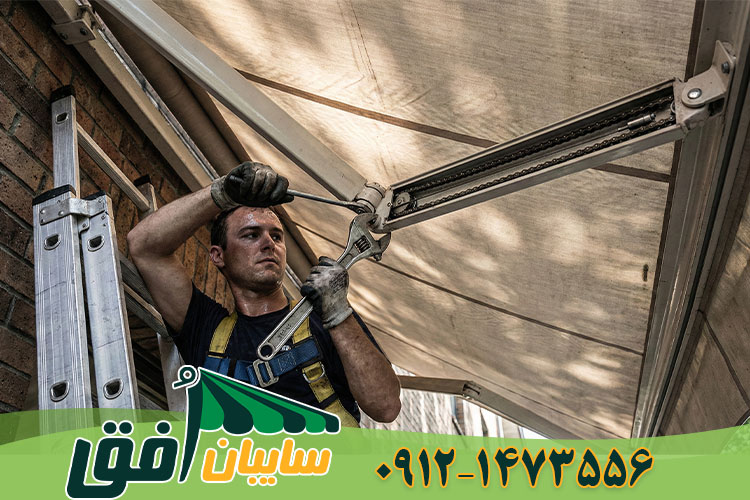 تعمیرکار در حال رگلاژ کردن و تنظیم زاویه شیب بازوهای سایبان بازویی جهت رفع افتادگی