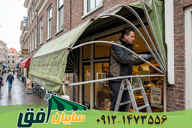 تکنسین در حال تعمیر گیربکس و تنظیم اسکلت فلزی سایبان کالسکه‌ای (کروک) سردرب فروشگاه