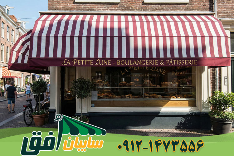 سایبان کالسکه ای راه راه قرمز و سفید نصب شده سردر مغازه برای جلوگیری از تابش آفتاب و زیبایی نما